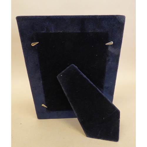 25 - A silver photograph frame with two patterned bordered ornament, on a fabric easel back  4.5