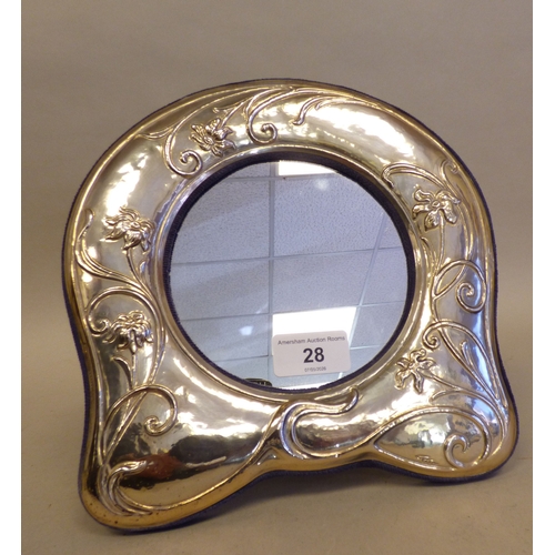 28 - An Art Nouveau influenced white metal photograph frame, the central mirrored cartouche 5