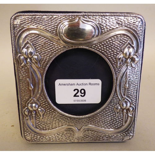 29 - An Art Nouveau silver photograph frame with floral and whiplash ornament  London 1913 the central ca... 