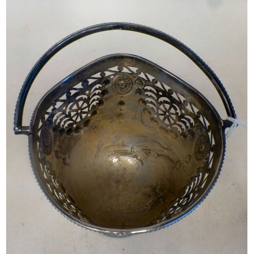 36 - A silver sugar basket of pedestal design with embossed garland ornament and a swing top handle&nbsp;... 