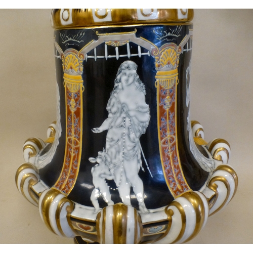 49 - A late 19thC porcelain pate-sur-pate pedestal vase and cover, decorated with panels, featuring class... 