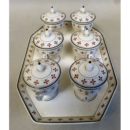 57 - A late 19thC Wedgwood creamware custard set, decorated in the manner of Alfred Powell  comprising si... 