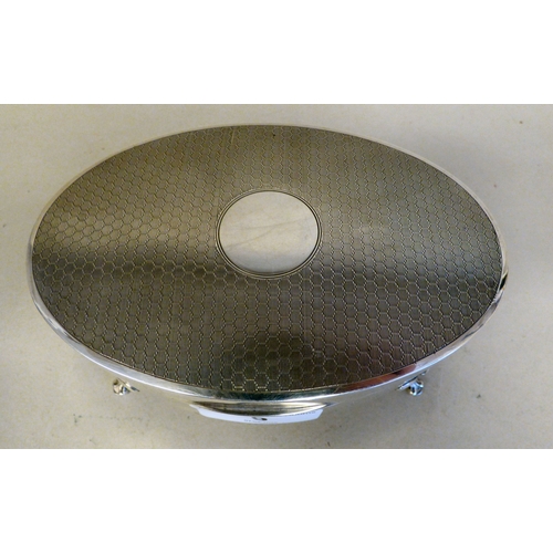 9 - A George V silver oval ring box with engine turned decoration, enclosing a fabric lined fitted inter... 