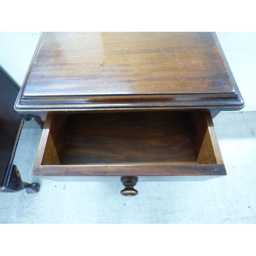 44 - An early 20thC mahogany bureau with a fall flap, over three graduated drawers, raised on carved, stu... 