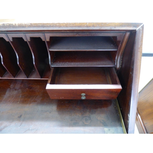 44 - An early 20thC mahogany bureau with a fall flap, over three graduated drawers, raised on carved, stu... 