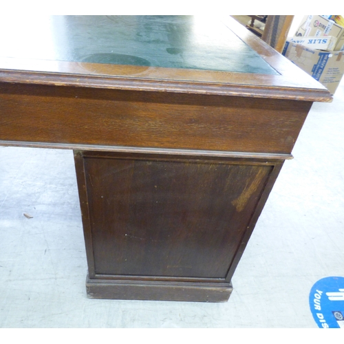 46 - An early 20thC oak nine drawer, twin pedestal desk, on a plinth&nbsp; 30