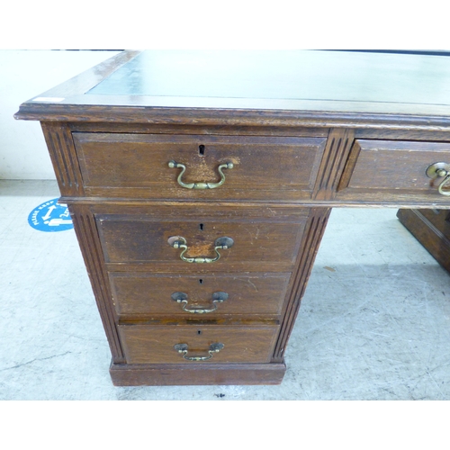 46 - An early 20thC oak nine drawer, twin pedestal desk, on a plinth&nbsp; 30