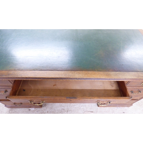 46 - An early 20thC oak nine drawer, twin pedestal desk, on a plinth&nbsp; 30