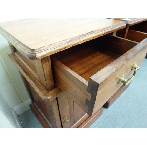 52 - A pair of modern fruitwood bedside chests with a single drawer, over a panelled door, raised on a pl... 