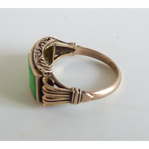 48 - A Chinese style yellow metal ring, set with four jade coloured stone tablets  stamped 14k  (approx. ... 