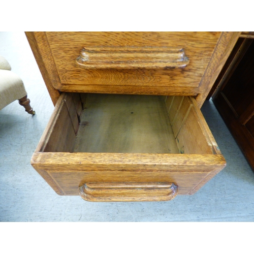 A late 19th/early 20thC oak twin pedestal seven drawer desk, on a ...