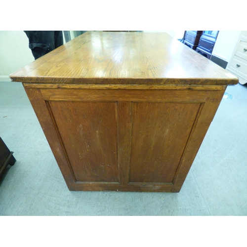 A late 19th/early 20thC oak twin pedestal seven drawer desk, on a ...