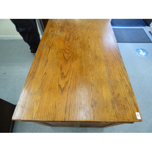 A late 19th/early 20thC oak twin pedestal seven drawer desk, on a ...