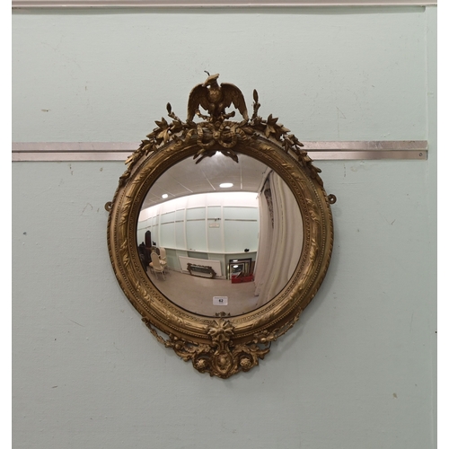 A Regency gilt gesso convex mirror, surmounted by a bird 31