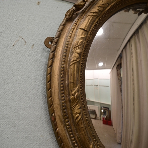 A Regency gilt gesso convex mirror, surmounted by a bird 31