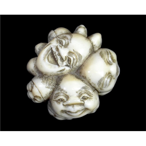 108 - λ A Japanese carved ivory pommel, Meiji, 19th century, carved with heads, signed, 4.5cm long