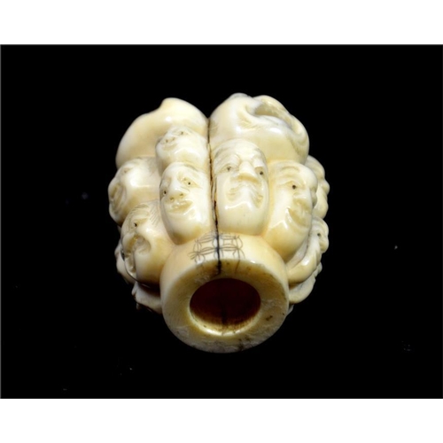 108 - λ A Japanese carved ivory pommel, Meiji, 19th century, carved with heads, signed, 4.5cm long