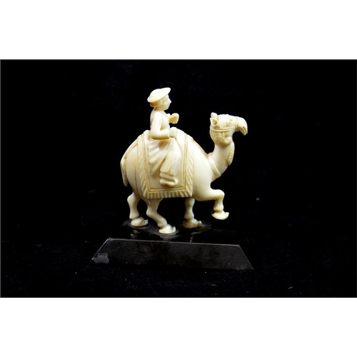 110 - λ An Oriental carved ivory figure of a man on camel, 19th century, Anglo Indian, on black marble bas... 