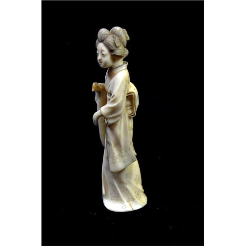 112 - λ A Japanese carved ivory okimono, Meiji, 19th century, modelled as a Geisha, 14cm high