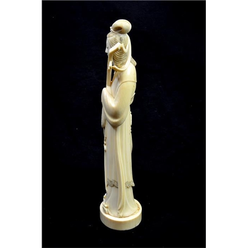 116 - λ A Japanese carved ivory Okimono, Meiji, late 19th century, modelled as a musician holding a string... 