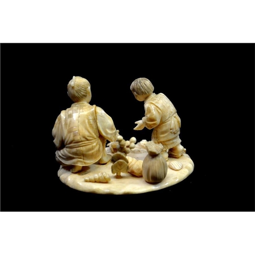 120 - λ A Japanese carved ivory okimono, Meiji, 19th century, modelled as a father and son cockle picking ... 