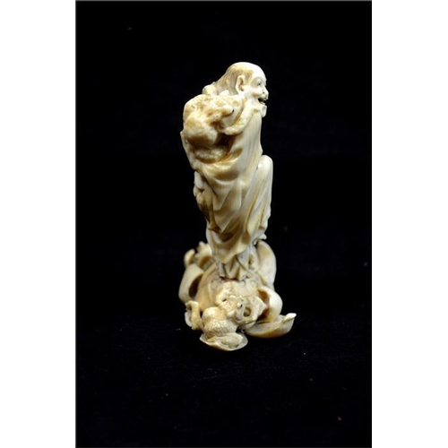 122 - λ A Japanese carved ivory okimono, Meiji, 19th century, modelled as a grotesque sage with toads, sta... 