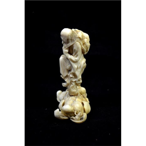 122 - λ A Japanese carved ivory okimono, Meiji, 19th century, modelled as a grotesque sage with toads, sta... 