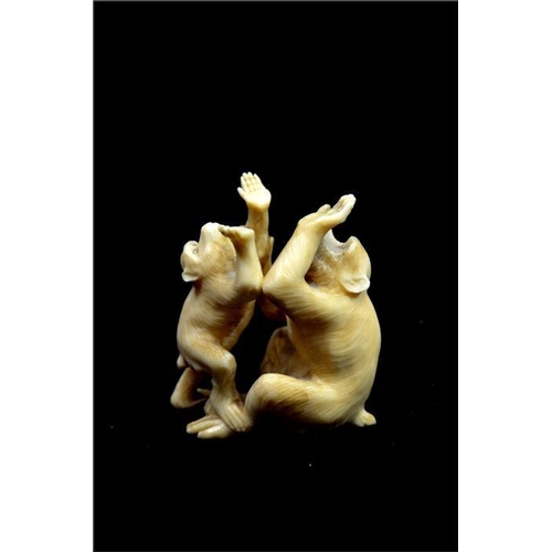 124 - λ A Japanese carved ivory okimono, Meiji, 19th century, modelled as an infant and adult monkey playi... 