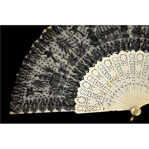 175 - A 19th century lace fan, with a black lace leaf decorated with figures, parrots, trees and buildings... 