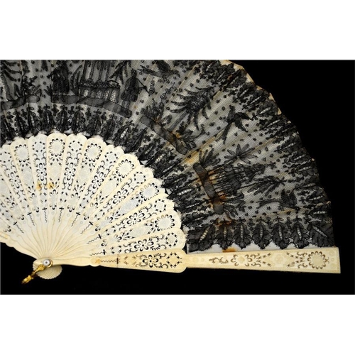 175 - A 19th century lace fan, with a black lace leaf decorated with figures, parrots, trees and buildings... 