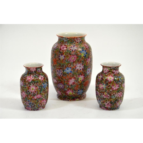 3 - A garniture of three Chinese famille rose miniature vases, carpet decorated with floral and foliate ... 