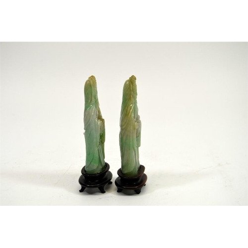 70 - A pair of carved Chinese jade type figures, on hardwood stands, 13cm high (2)