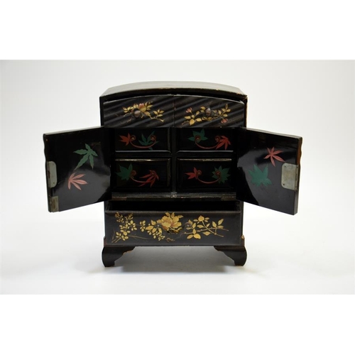 89 - A Japanese lacquer miniature chest, two drawers over double doors, opening to reveal four further la... 