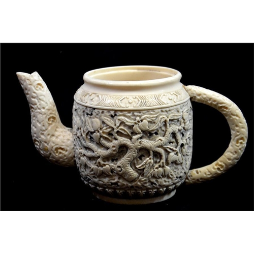 99 - λ A Chinese carved ivory teapot, 19th century, decorated to each side with a fruiting peach tree, be... 