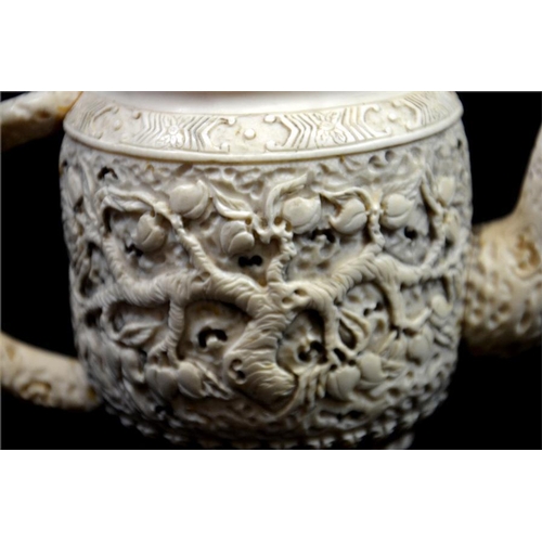 99 - λ A Chinese carved ivory teapot, 19th century, decorated to each side with a fruiting peach tree, be... 