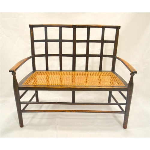 203 - A Liberty and Co. Arts and Crafts childs settle, stained beech with lattice back and cane seat, circ... 