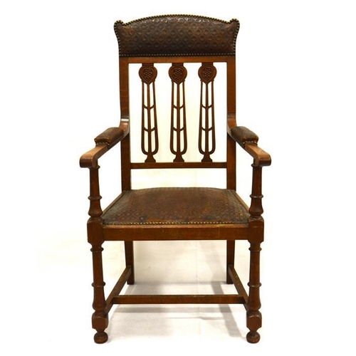 205 - A large arts and crafts oak library/gentleman's carved chair with original tooled leather, all brass... 