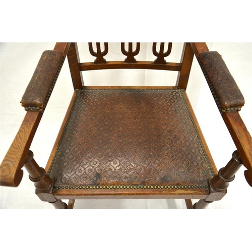 205 - A large arts and crafts oak library/gentleman's carved chair with original tooled leather, all brass... 