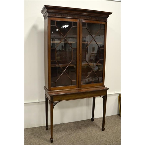 214 - An Edwardian Chippendale style mahogany glazed bookcase on stand, astragal glazed doors with blind f... 