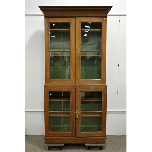 225 - A Victorian oak two tier bookcase cabinet, glazed doors and shelved interiors, 105cm wide, 208cm hig... 