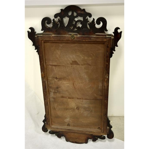 253 - A George II Chippendale style mahogany fretted mirror, the pediment carved with phoenix, the base wi... 