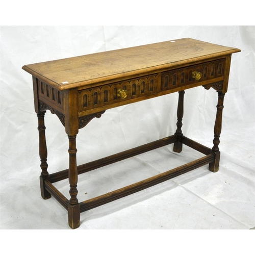 260 - An Old Charm style solid oak two drawer side table, jointed construction, relief moulded arcading an... 