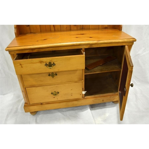 263 - A Victorian pine dresser and rack, three graduated drawers with cupboard beside, below a two shelf r... 