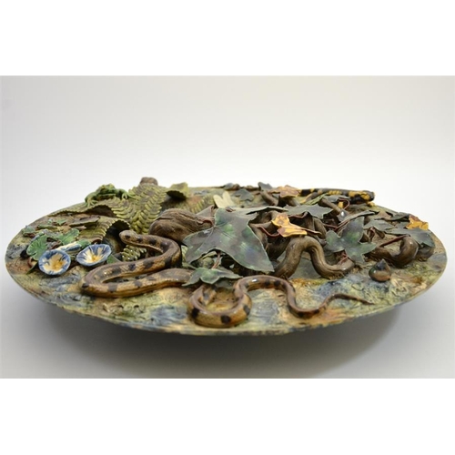 1592 - A large Palissy ware charger, modelled in high relief as a woodland pond with frogs, insects and rep... 