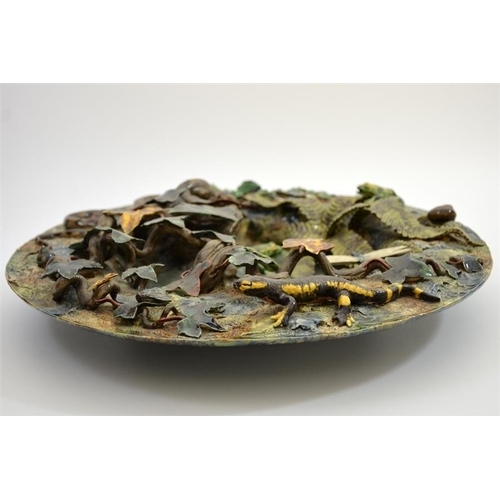 1592 - A large Palissy ware charger, modelled in high relief as a woodland pond with frogs, insects and rep... 