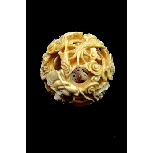 96 - λ A Chinese carved ivory puzzle ball on stand, 19th century, the six sphere ball, carved with dragon... 