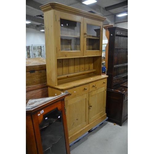 245 - A Victorian pine bookcase on cabinet, the two bay dresser base with drawers above cupboards, the rac... 