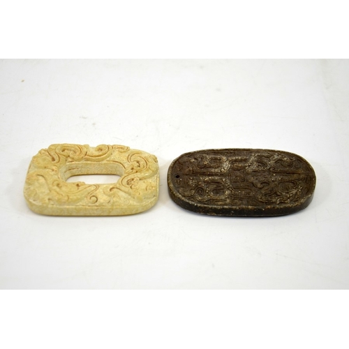 15 - Two Chinese archaistic carved stone pendants, one of jade type stone, ring form, modelled in relief ... 