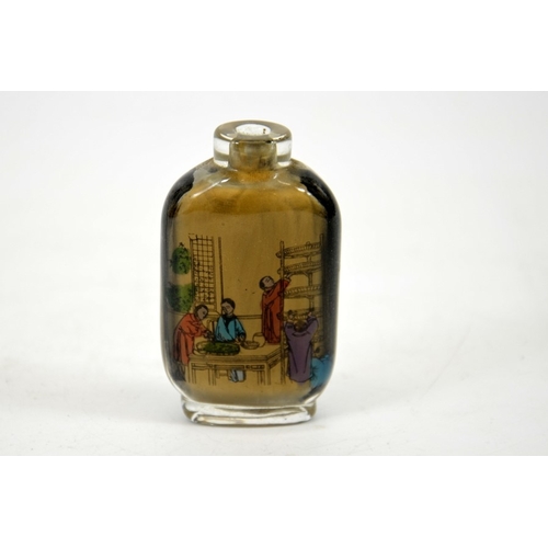 16 - A Chinese reverse painted glass snuff bottle, an interior cooking scene to one side, the reverse wit... 