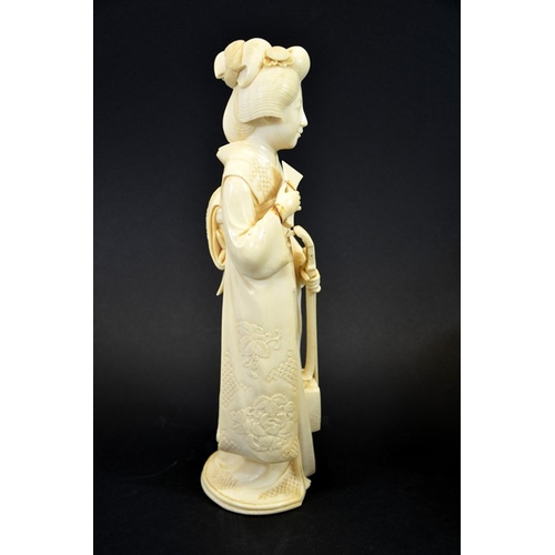 22 - λ A 19th century Japanese carved ivory okimono of a Geisha, Meiji, modelled with a stringed instrume... 